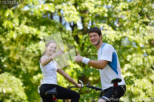 Image of Happy couple ridine bicycle outdoors