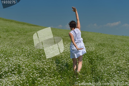 Image of Young happy woman in green field