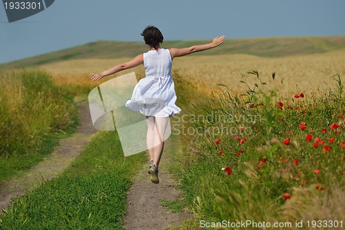 Image of young woman in wheat field at summer