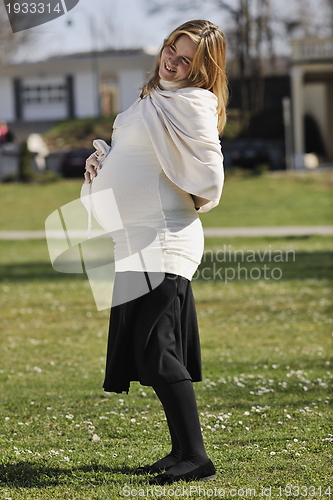Image of happy young pregnant woman outdoor