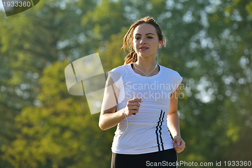 Image of Young beautiful  woman jogging at morning in park