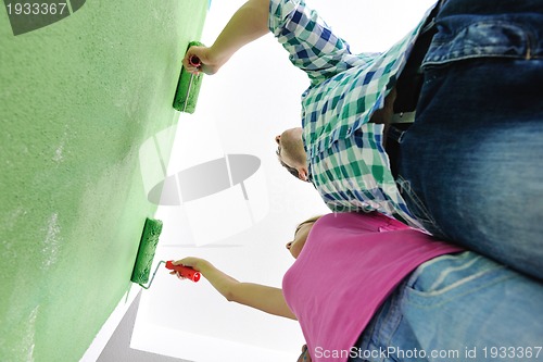 Image of happy couple paint wall at new home