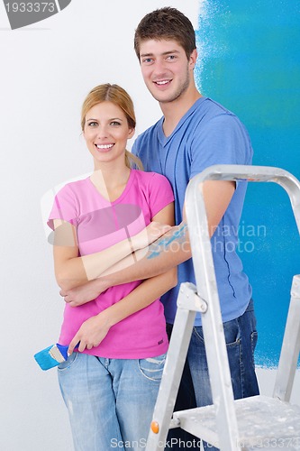 Image of happy couple paint wall at new home