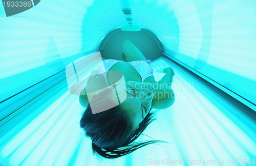 Image of Beautiful young woman tanning in solarium