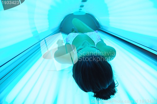 Image of Beautiful young woman tanning in solarium