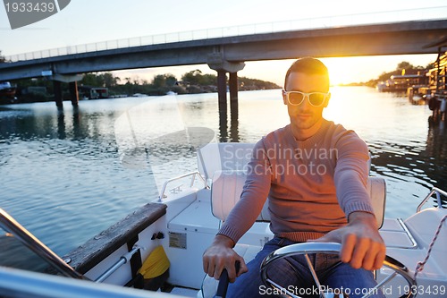 Image of portrait of happy young man on boat