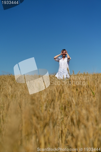 Image of young woman in wheat field at summer