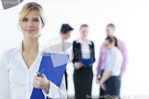 Image of business woman standing with her staff in background