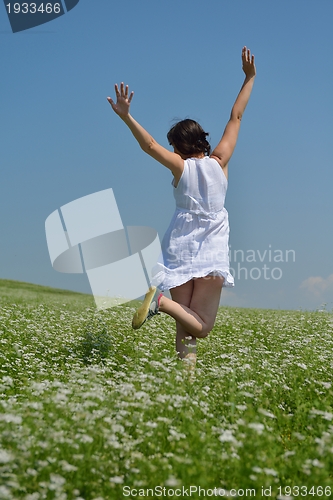 Image of Young happy woman in green field