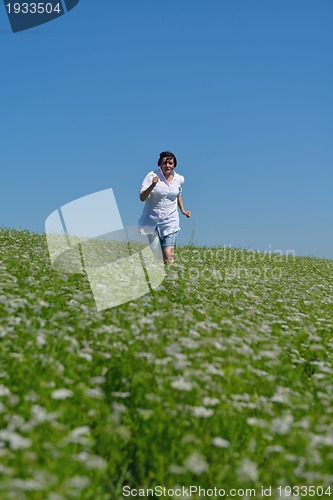 Image of Young happy woman in green field