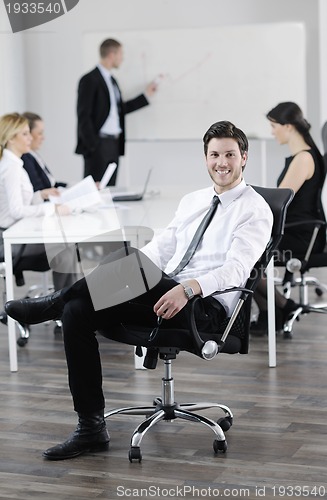 Image of handsome young business man with colleagues in background