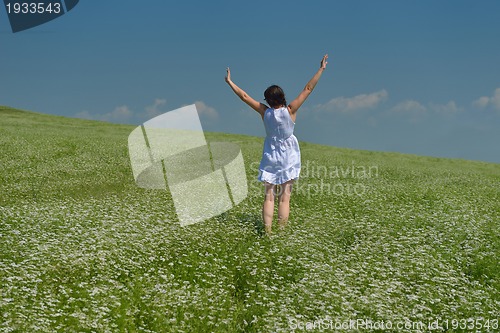 Image of Young happy woman in green field