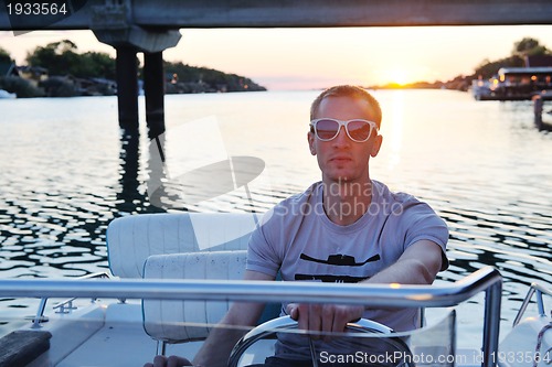Image of portrait of happy young man on boat
