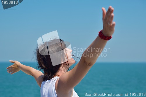 Image of happy young woman with spreading arms to sky
