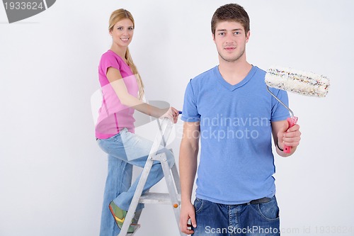 Image of happy couple paint wall at new home