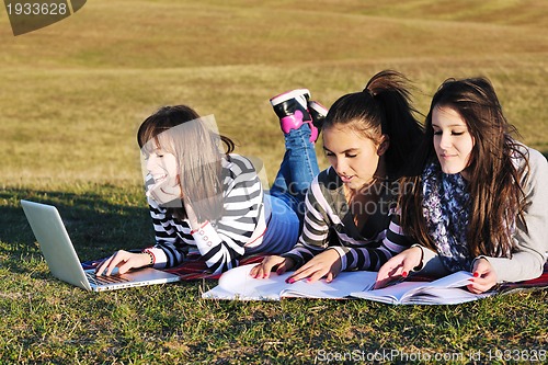 Image of group of teens working on laptop outdoor