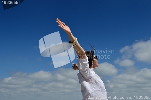 Image of young woman with spreading arms to sky