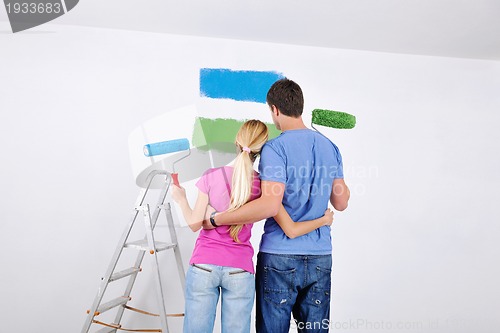 Image of happy couple paint wall at new home