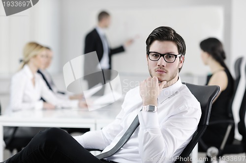 Image of handsome young business man with colleagues in background