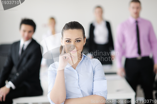 Image of business woman standing with her staff in background