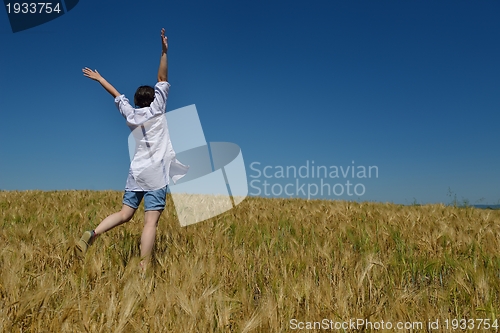Image of young woman in wheat field at summer