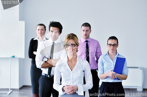 Image of business woman standing with her staff in background