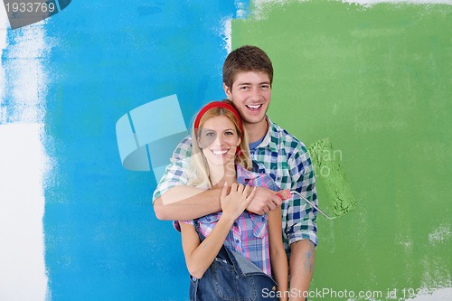 Image of happy couple paint wall at new home