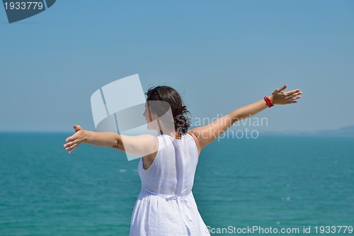 Image of happy young woman with spreading arms to sky