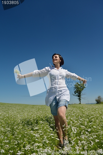 Image of Young happy woman in green field