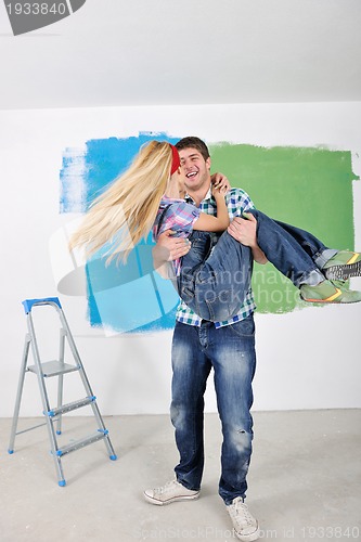 Image of happy couple paint wall at new home