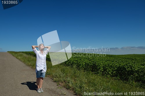 Image of Young happy woman in green field