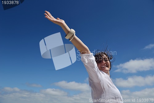 Image of happy young woman with spreading arms to sky