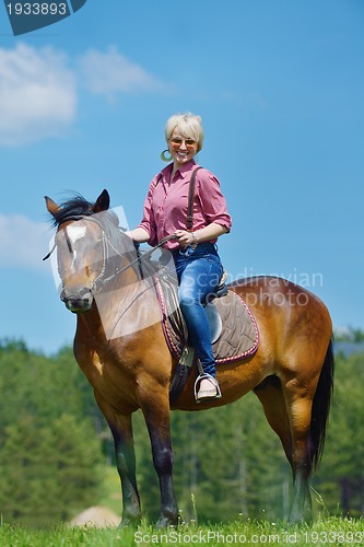 Image of happy woman  on  horse