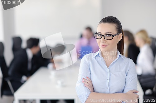 Image of business woman standing with her staff in background
