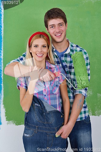 Image of happy couple paint wall at new home