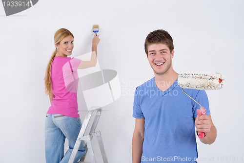 Image of happy couple paint wall at new home