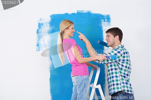 Image of happy couple paint wall at new home