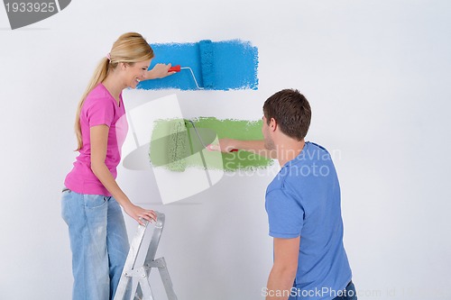 Image of happy couple paint wall at new home