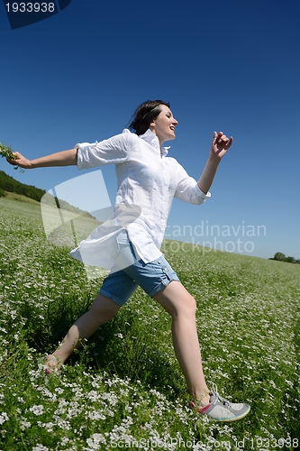 Image of Young happy woman in green field