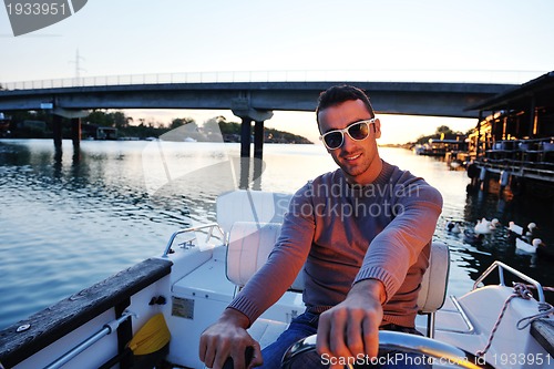 Image of portrait of happy young man on boat
