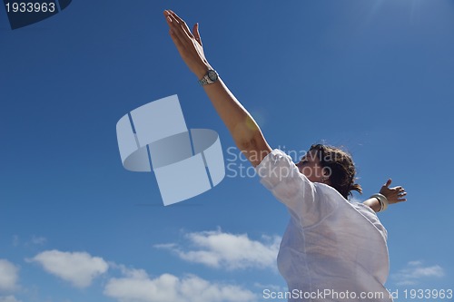 Image of happy young woman with spreading arms to sky