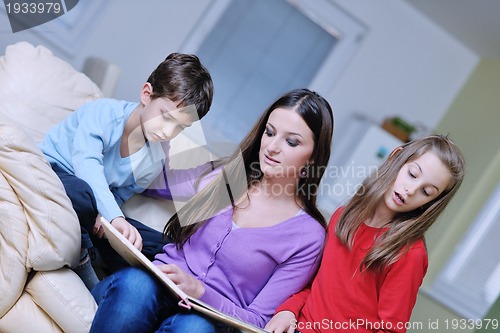 Image of young mom play with their kids at home and reading book