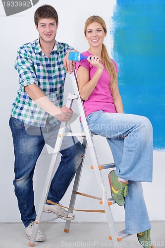 Image of happy couple paint wall at new home