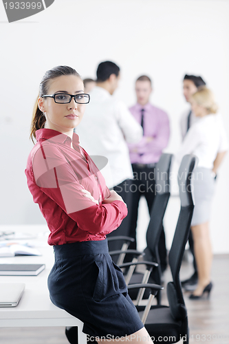 Image of business woman standing with her staff in background