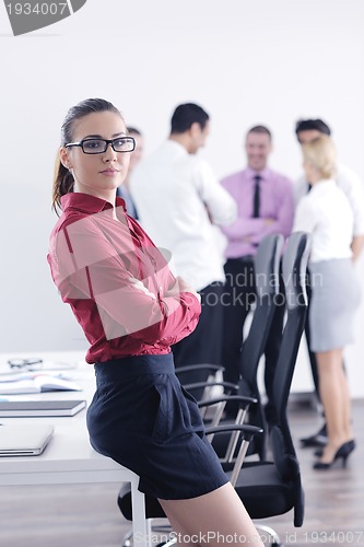 Image of business woman standing with her staff in background
