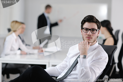 Image of Portrait of a handsome young business man with colleagues in bac