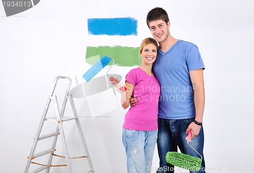 Image of happy couple paint wall at new home