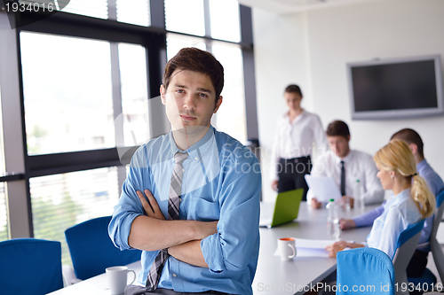 Image of business man  on a meeting in offce with colleagues in backgroun