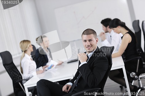 Image of handsome young business man with colleagues in background