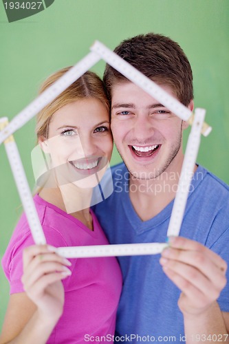 Image of happy couple paint wall at new home